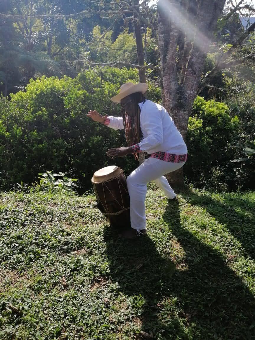 Percusionista de Sonidos Profundos interpretando tambor al aire libre, contraluz